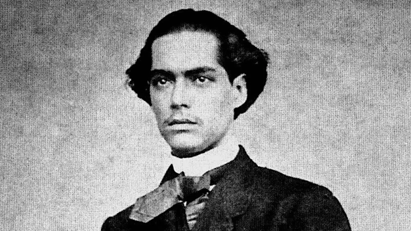 Retrato em preto e branco de Castro Alves jovem, de cabelo ondulado, bigode fino e gravata larga, poeta baiano que teve o pé amputado sem anestesia em 1869