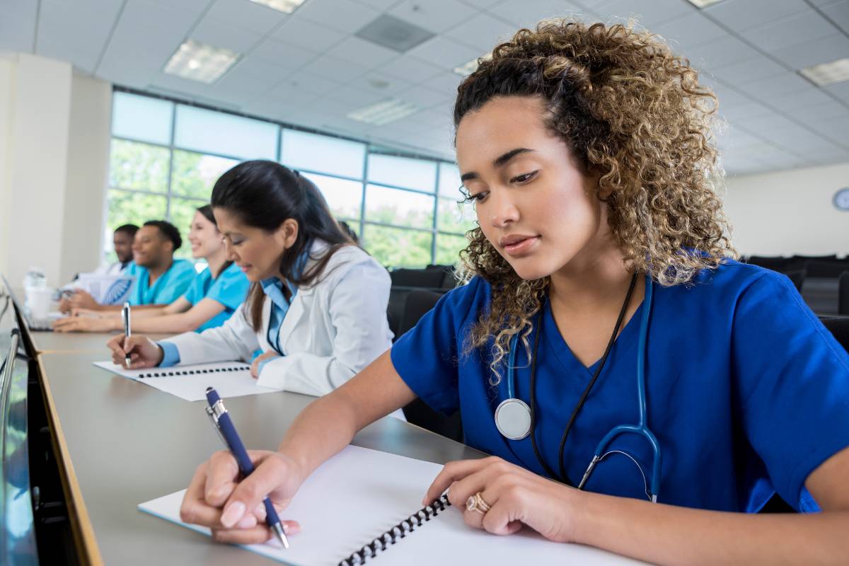 Uma estudante de medicina fazendo anotações no caderno