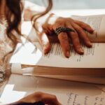 Uma mulher lendo um livro e escrevendo uma resenha