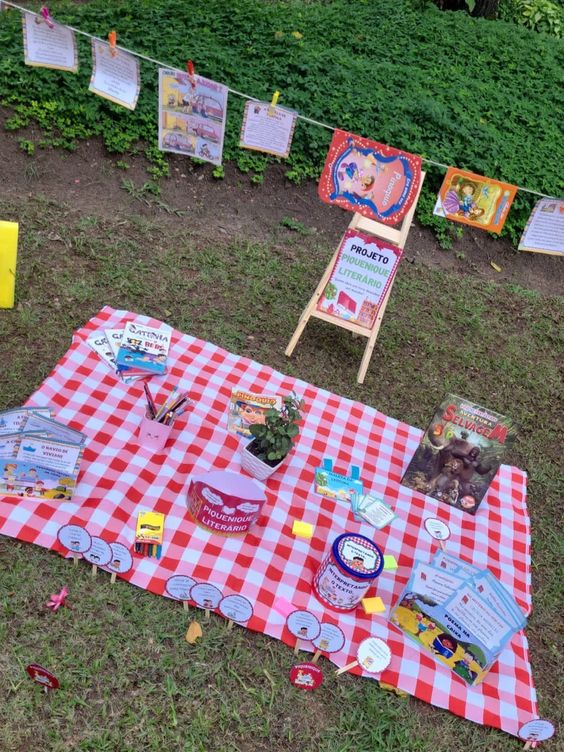 Piquenique literário, com uma toalha xadrez e branca, livros e alimentos