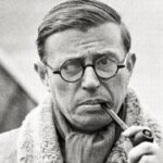 Uma foto preta e branca de Jean Paul Sartre fumando um cachimbo